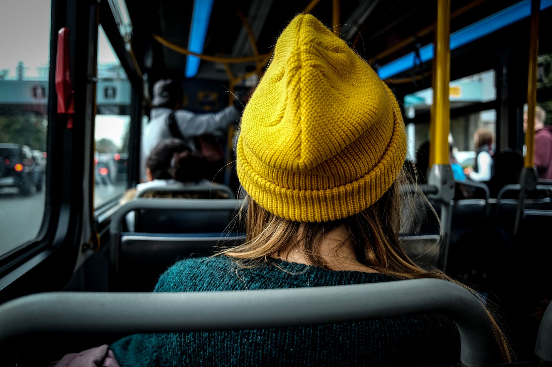 woman in yellow beanie hat sitting in bus